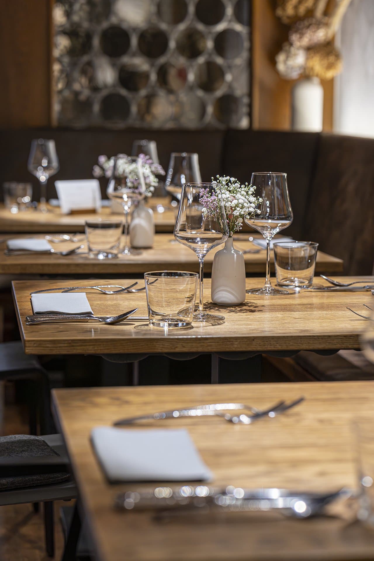 Elegant gedeckter Tisch in einem Restaurant mit Blumen und Weingläsern.