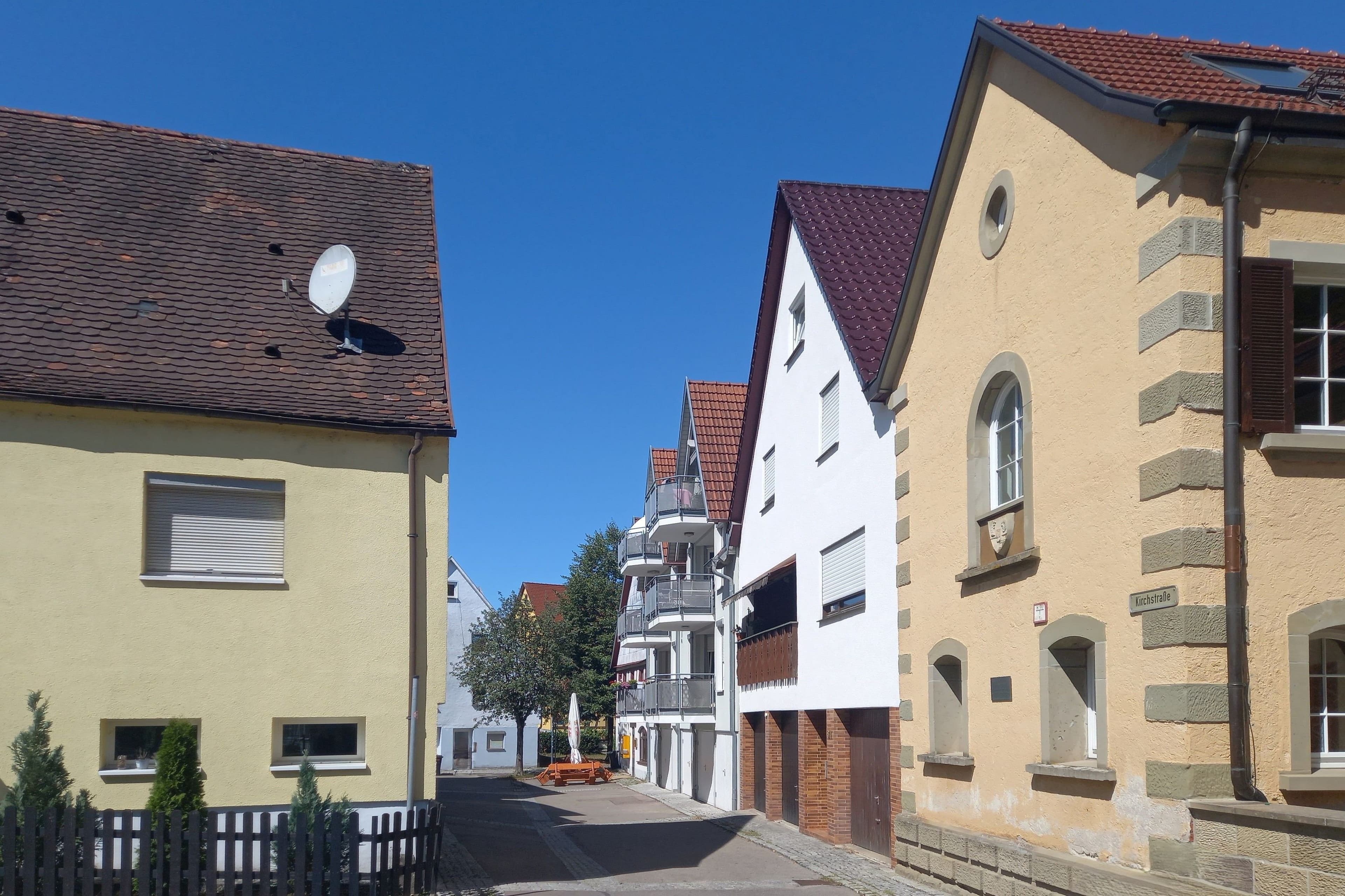 Straßenszene mit traditionellen Häusern und blauem Himmel.