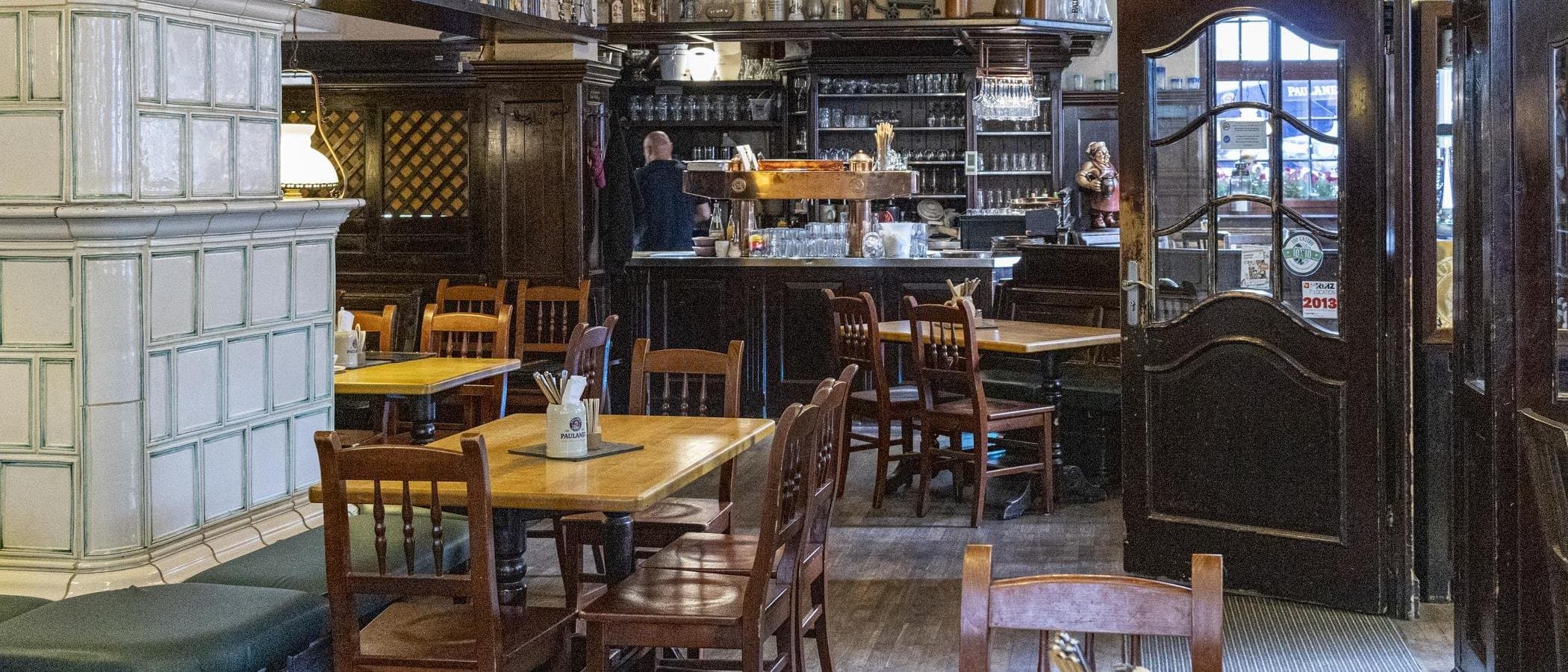 Innenraum eines traditionellen Restaurants mit Holzmöbeln und Bar.