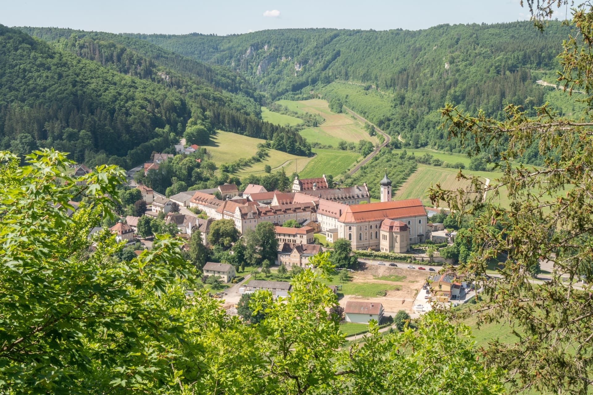 Aussicht vom oben auf die Gebäude des Kloster Beuron, umgeben von bewaldeten Hängen