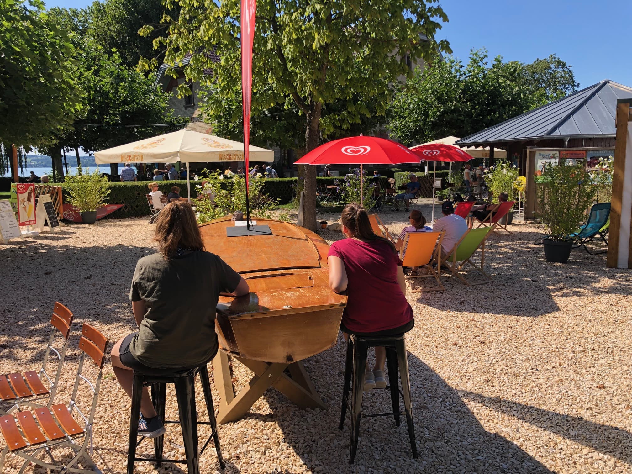 Zwei Personen sitzen auf Barhockern an einem Tisch der aussieht wie ein Segelboot