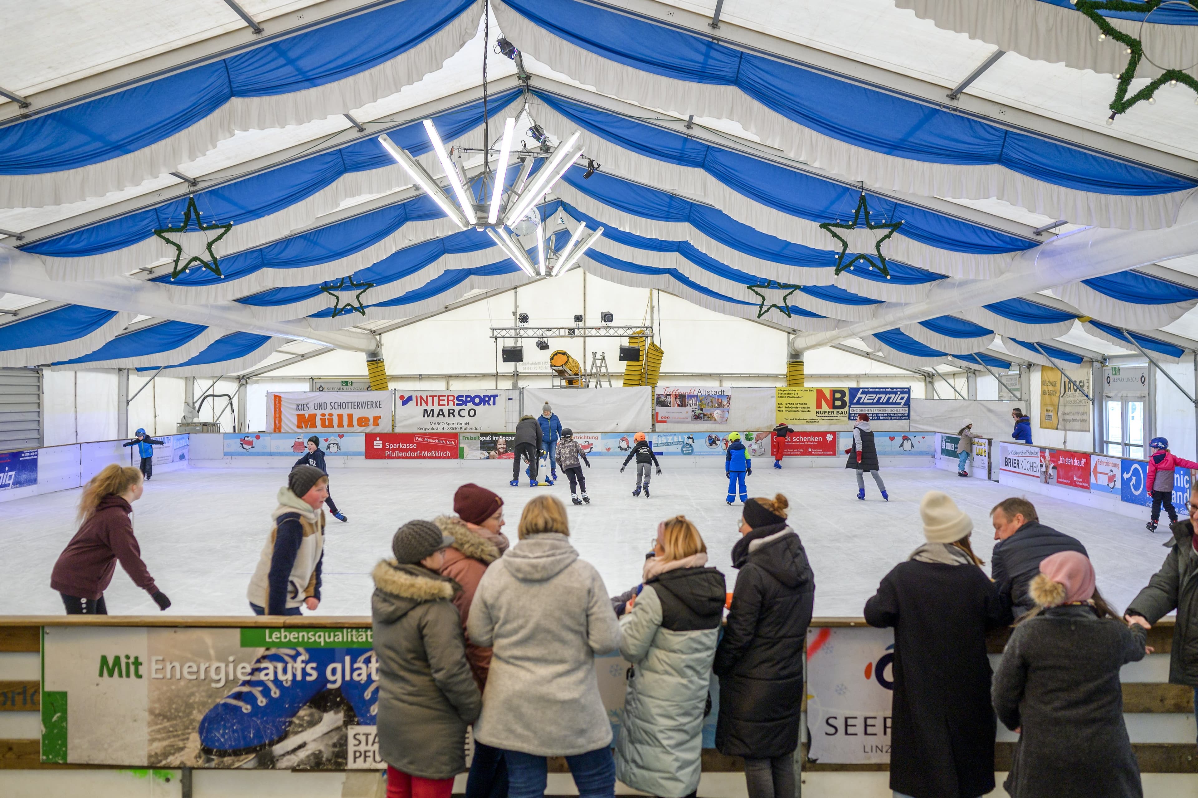 Zuschauer hinter der Bande der gefüllten Eisfläche