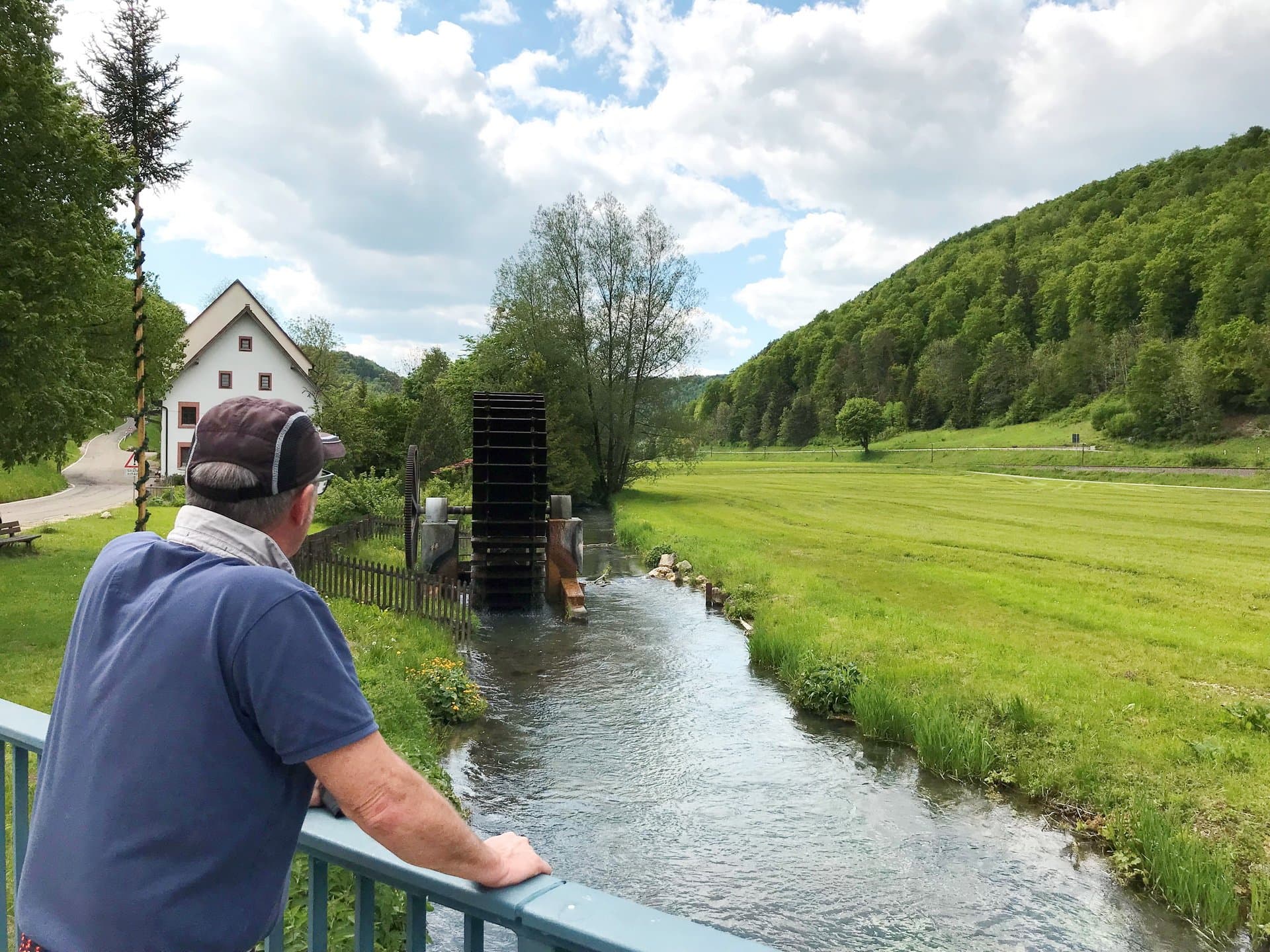 Wanderer an Brücke vor Historischem Mühlrad in Talsteußlingen.