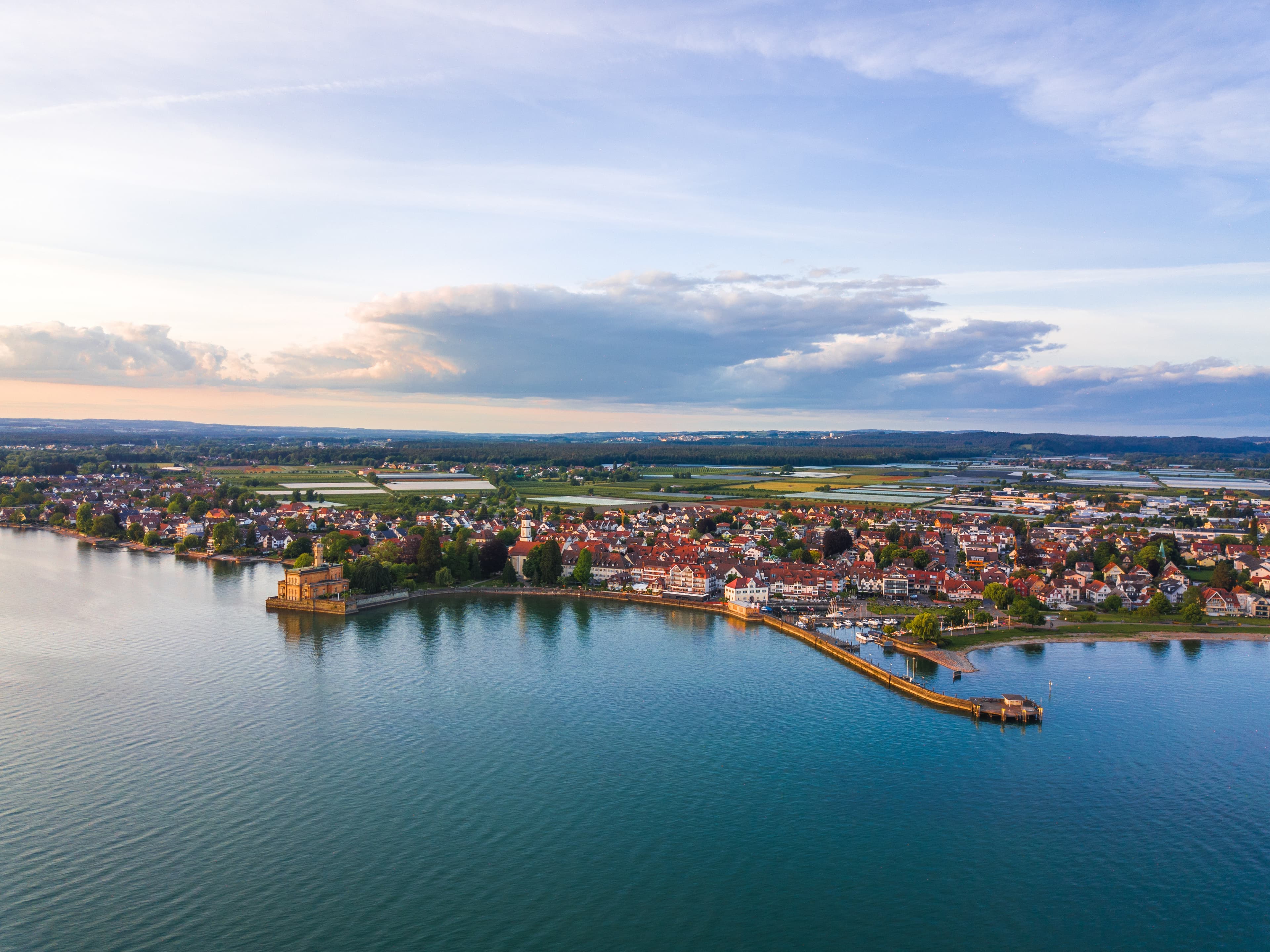 Panorama-Luftaufnahme von Langenargen. Zu sehen ist die Gemeinde mit Schloss Montfort, Uferpromenade und Gemeindehafen, sowie der Ausblick in Richtung Oberdorf.