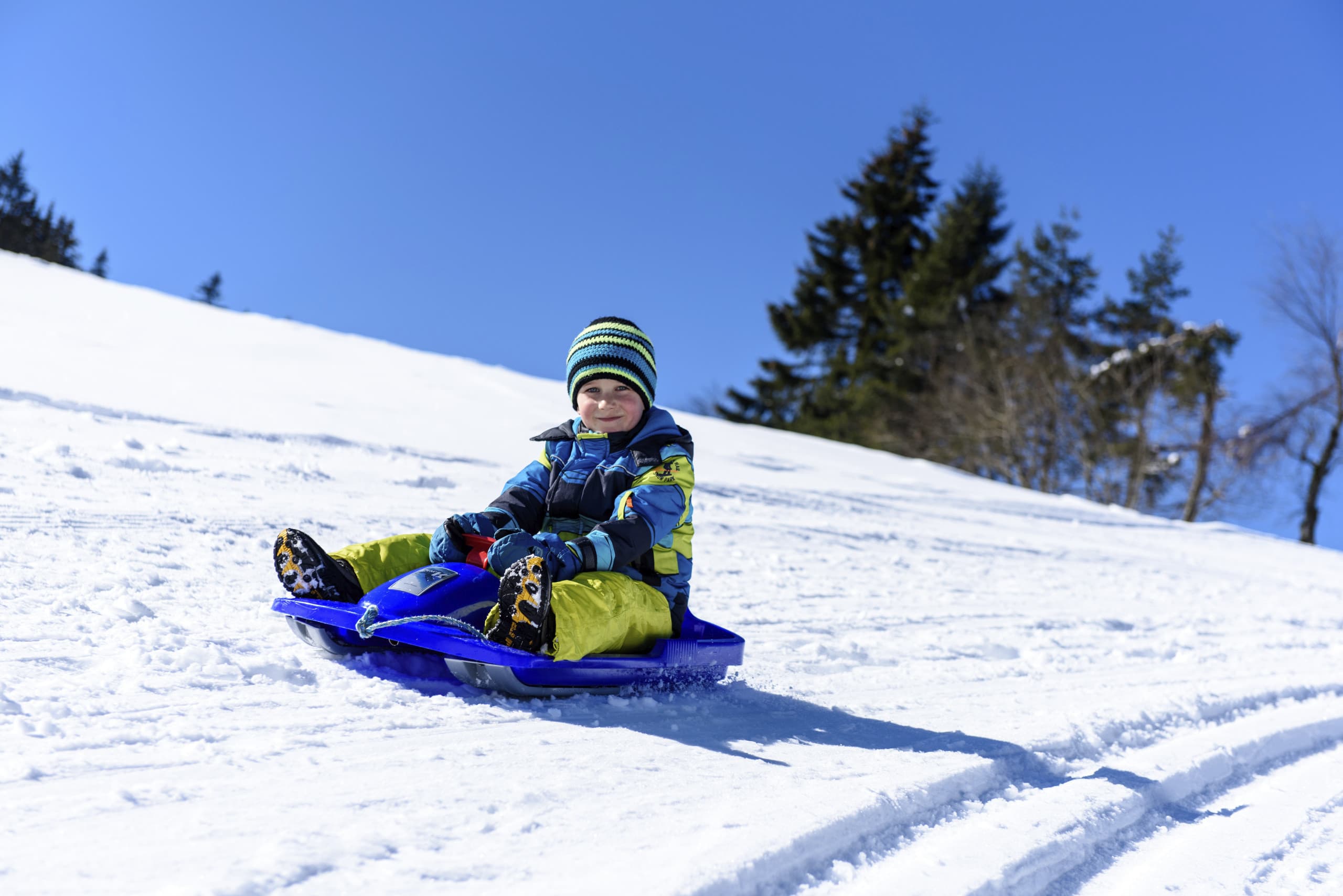 Kleiner Junge auf Rodelschlitten