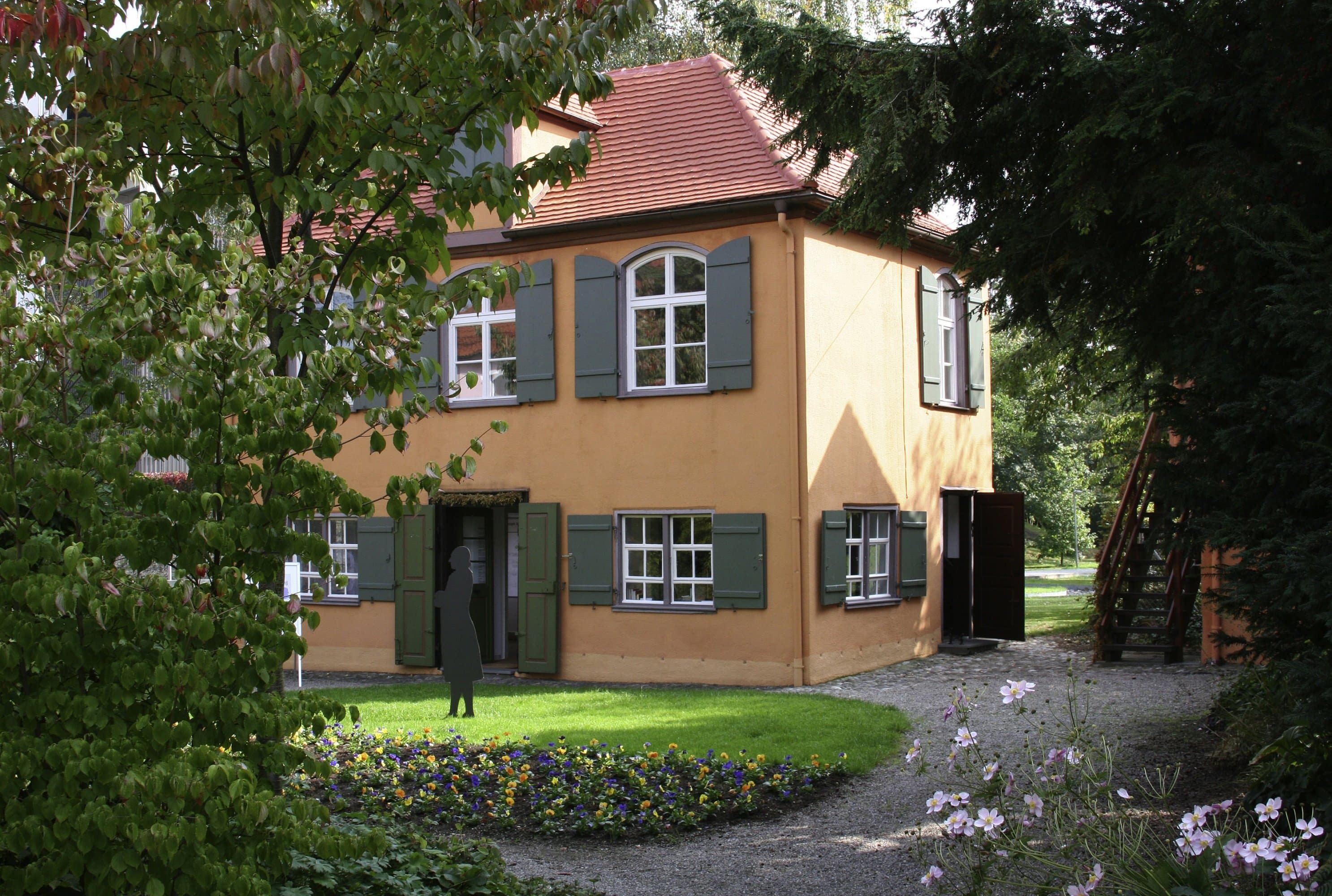 The Wieland garden shed nestled among trees and flower beds.