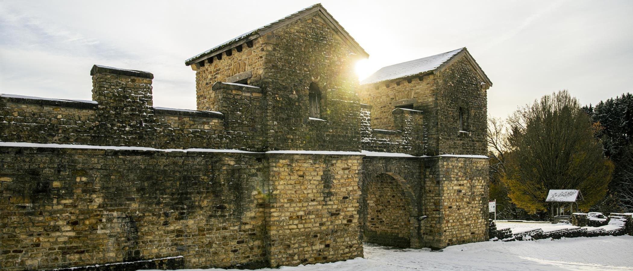 Römisches Ostkastell im Schnee mit Sonnenstrahlen.