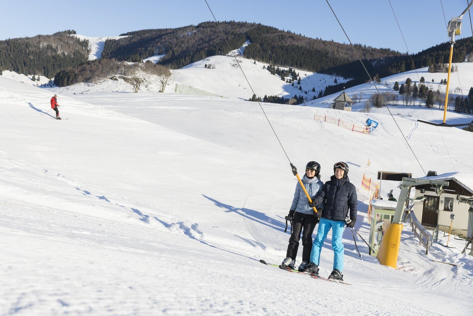 Paar nutzt eine Skilift im Hintgrund verscheinte Berge