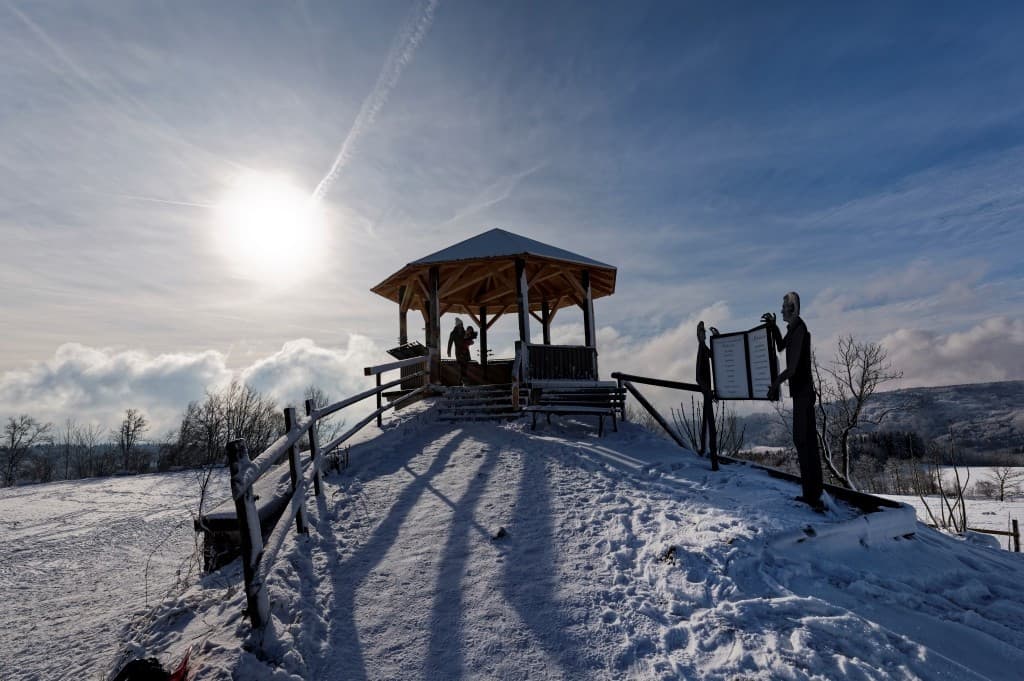Der Aussichtspavillon auf dem Höchsten inmitten der Schneelandschaft gegen die Sonne fotografiert.