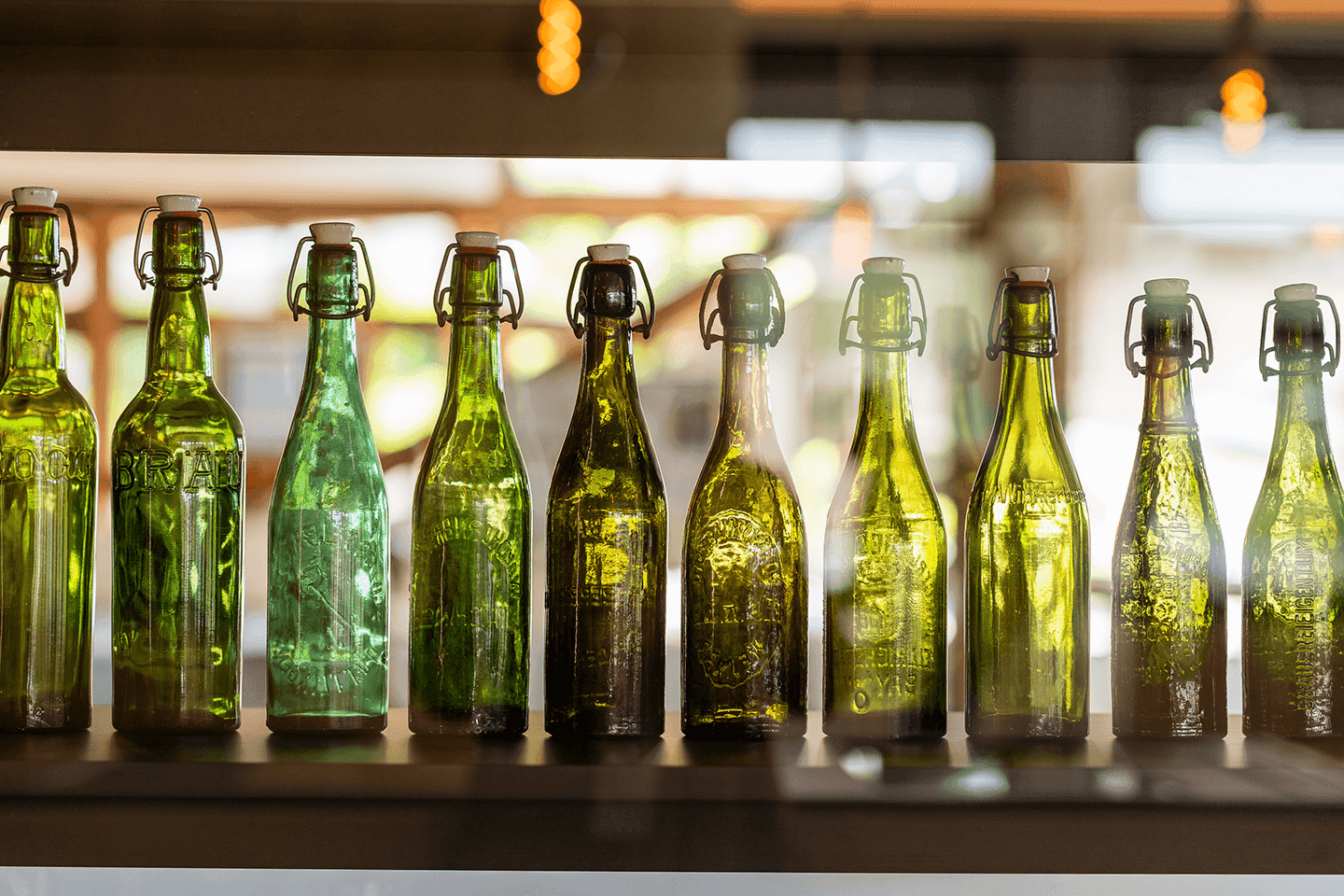 Glass bottles lined up next to each other in different shades of green.