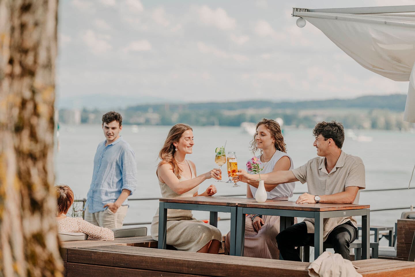 Freunde stoßen im Rothaus Biergarten des Steigenberger Inselhotels in Konstanz auf einen gelungenen Tag an