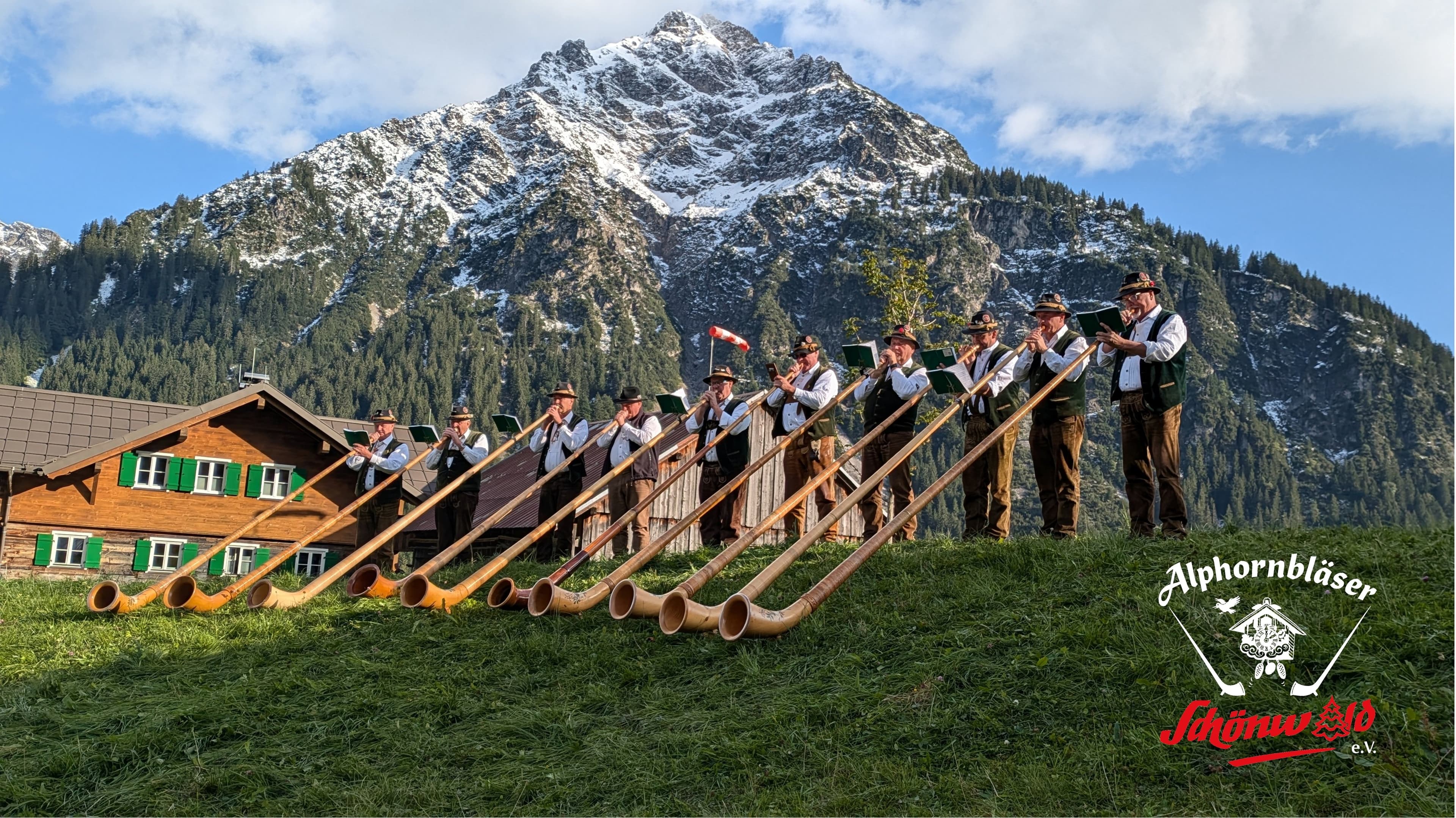 Die Alphornbläser Schönwald vor einer Bergkulisse