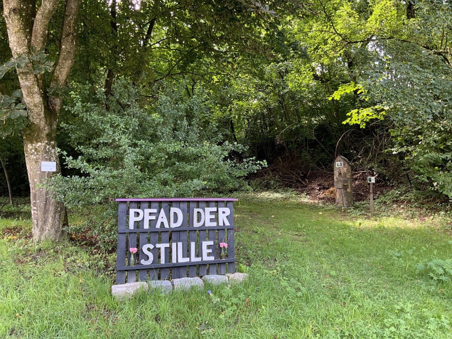 Ein Schild weist auf den Pfad mit der Schrift Pfad der Stille hin