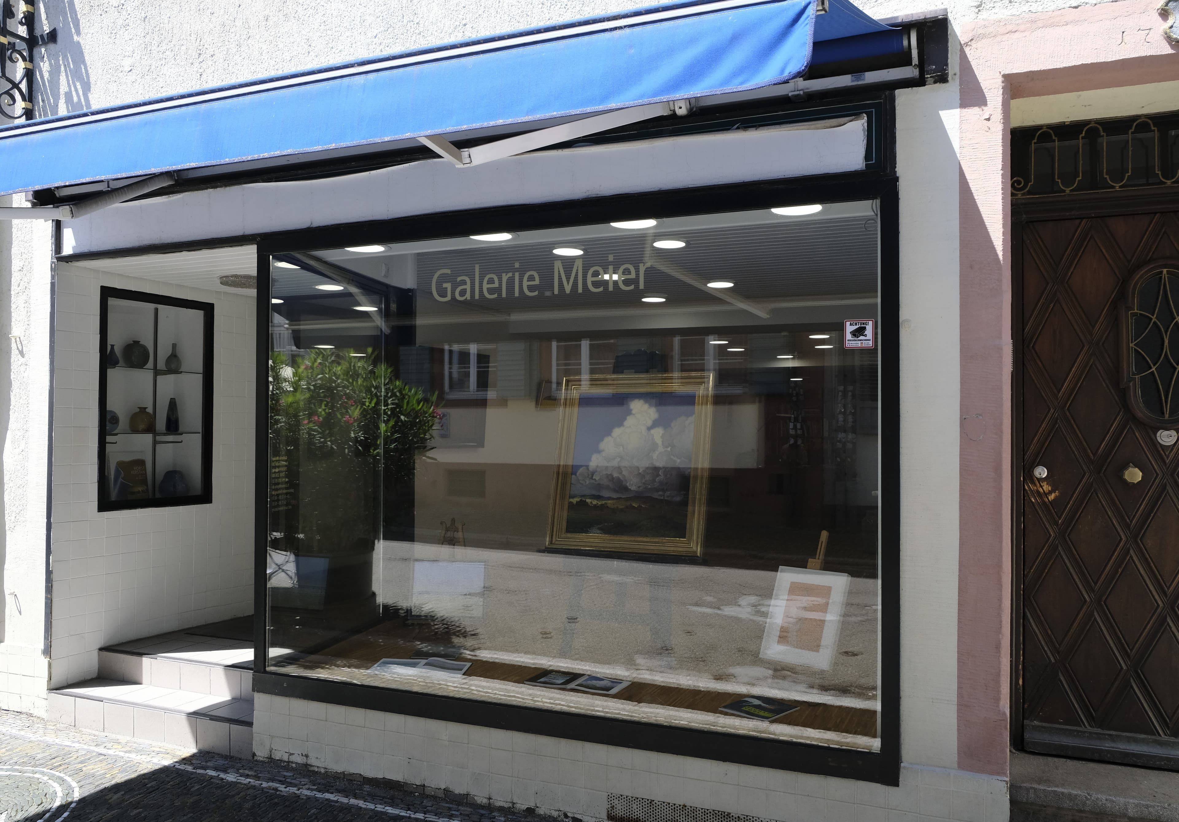 Außenansicht der Galerie Meier mit Schaufenster und Kunstwerken.