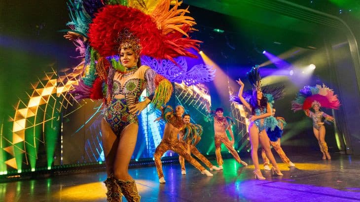 Female artists present a stage show, dressed in elaborate costumes