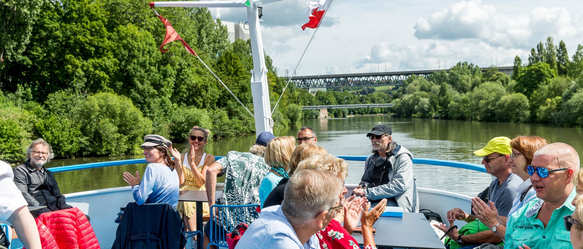 Menschen genießen eine Bootsfahrt auf dem Neckar bei sonnigem Wetter.