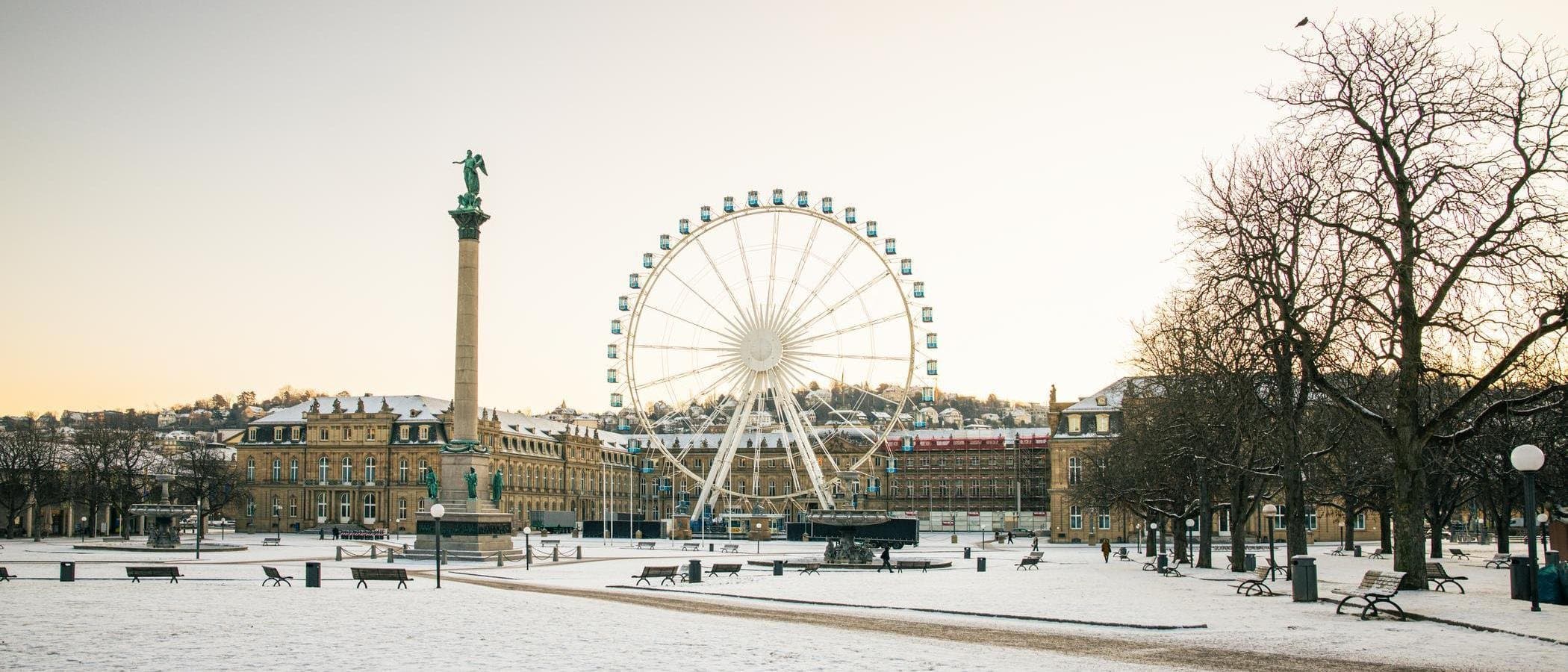 Schlossplatz in Stuttgart mit schneebedecktem Boden, einer Säule und Neues Schloss.