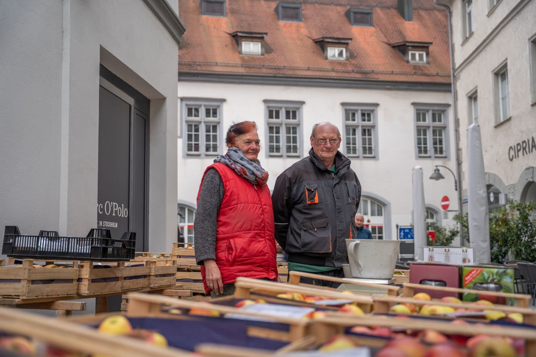 Zwei Verkäufer in Ihrem Obststand auf dem Ravensburger Wochenmarkt.