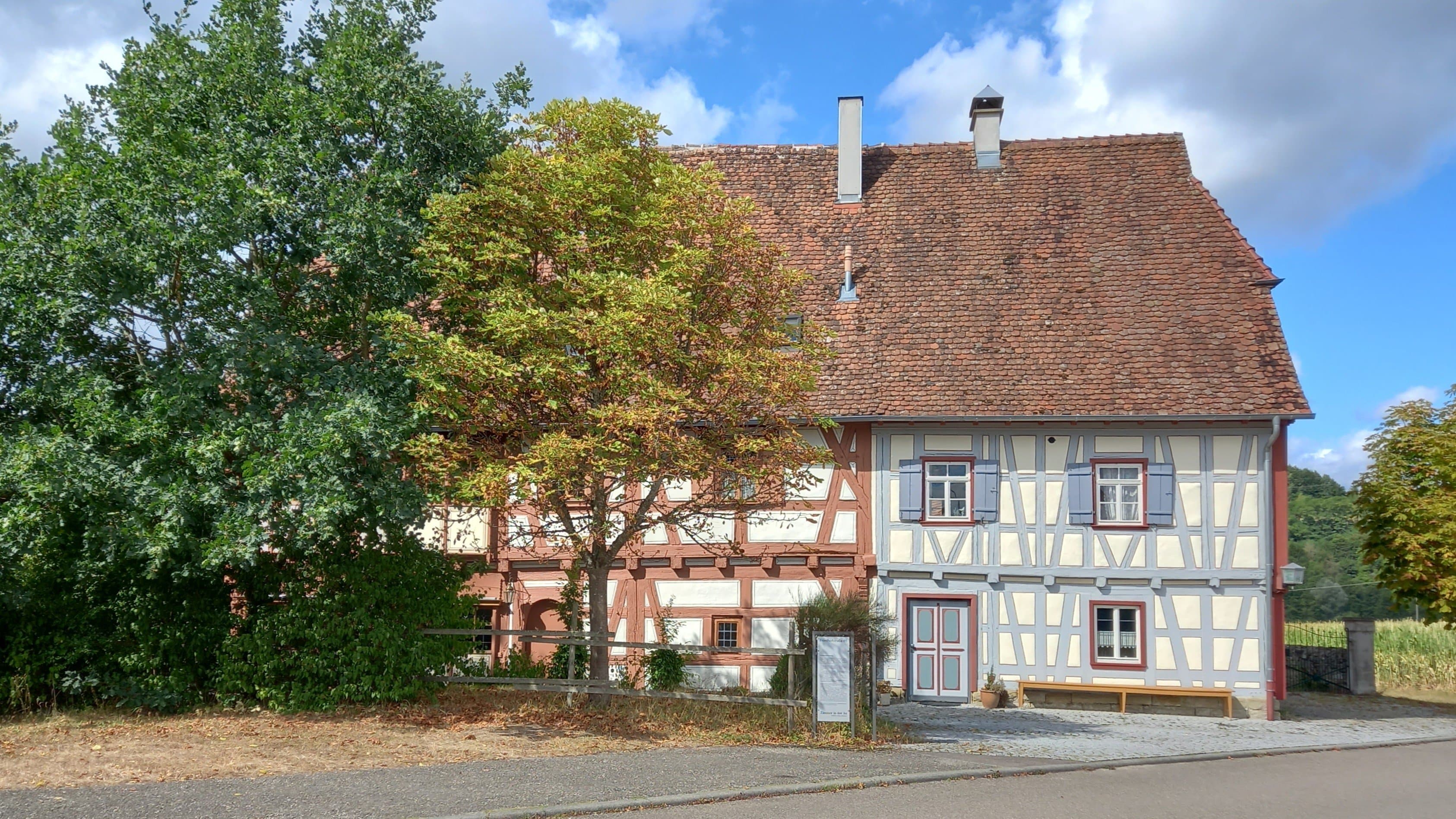 Fachwerkhaus in Gaildorf mit Bäumen im Vordergrund.