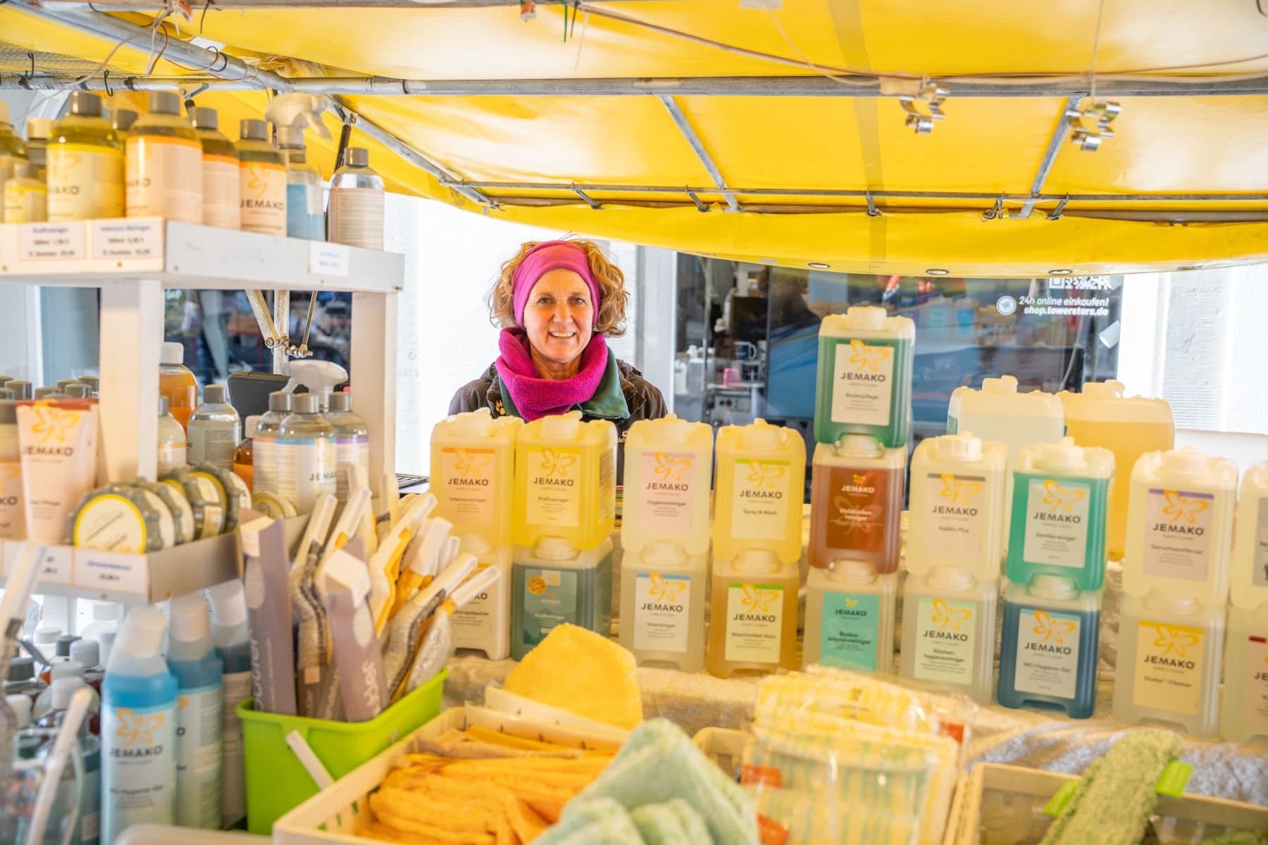 Verkäuferin in Ihrem Stand mit Putzmittelprodukten auf dem Wochenmarkt in Ravensburg.