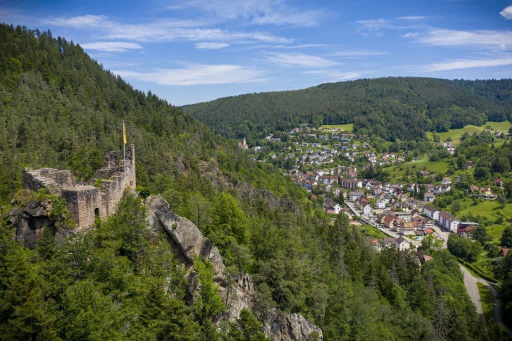 Auf dem Bild ist ein Luftbild mit Sicht auf die Burgruine Falkenstein und die Talstadt Schramberg zu sehen. Zudem bietet es ein wunderschönes Panorama auf die Schwwarzwaldlandschaft.