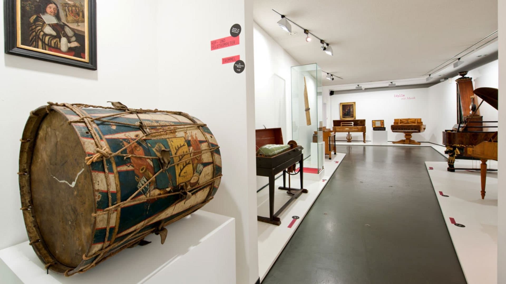 Ausstellung von Musikinstrumenten in einem Museum mit Trommel im Vordergrund.
