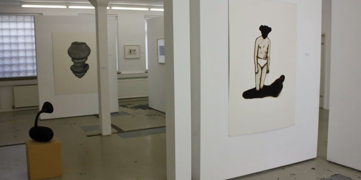 Innenansicht einer Kunstgalerie mit Gemälden und Skulpturen.