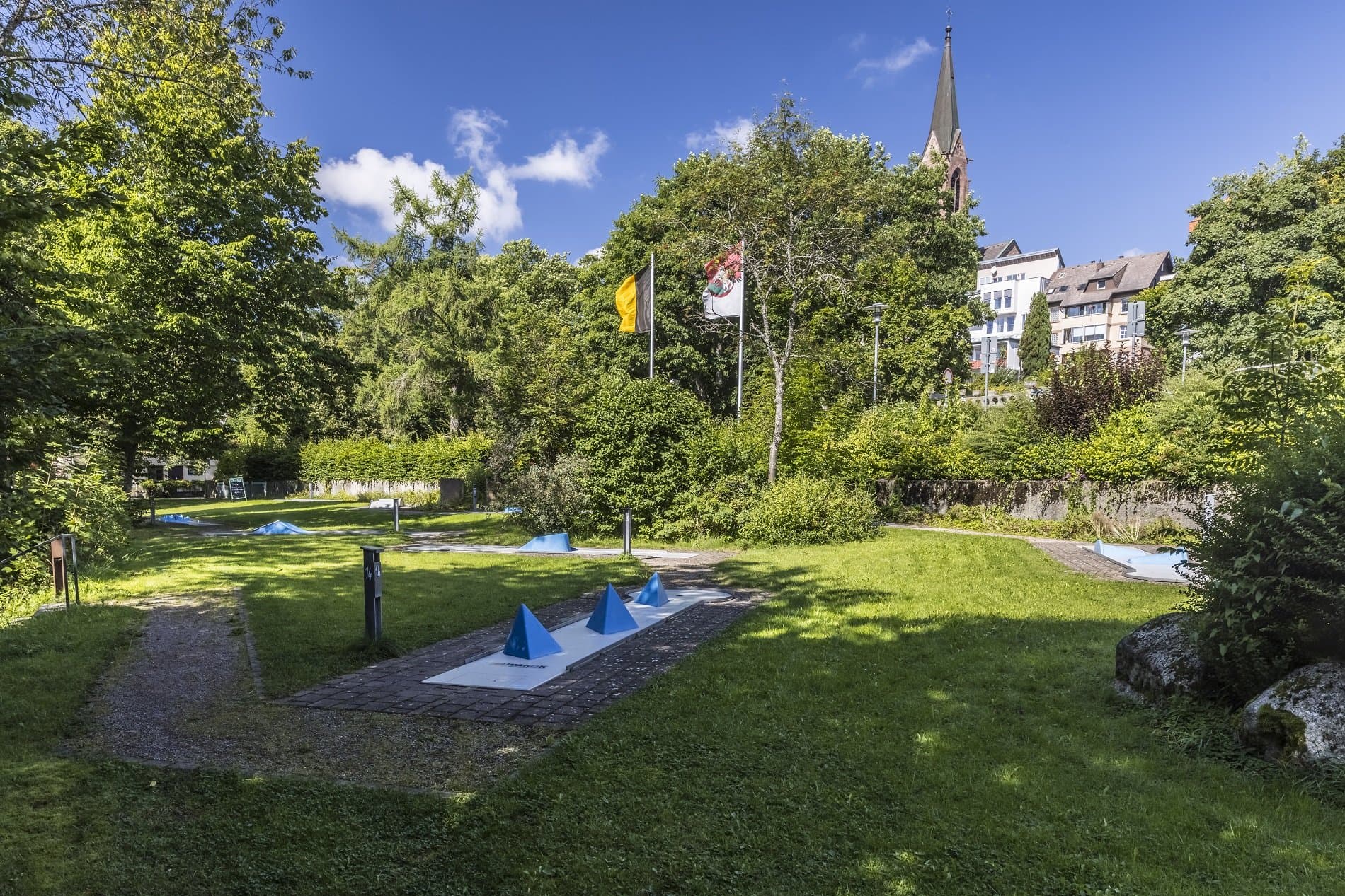 Golfbahnen durch Wiesen mit Bäumen im Hintergrund